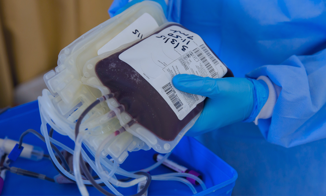Image of a young girl receiving a medical examination from a nurse using a digital thermometer, while her mother closely watches. The nurse, in blue scrubs, is attentively engaging with the child, who appears calm. The mother, standing beside her daughter, looks on with concern. The setting is a medical office, illuminated in a serene blue tone to create a calm and professional atmosphere.