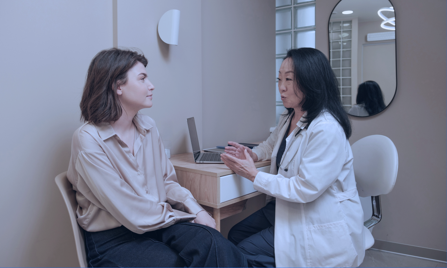 Image of a young girl receiving a medical examination from a nurse using a digital thermometer, while her mother closely watches. The nurse, in blue scrubs, is attentively engaging with the child, who appears calm. The mother, standing beside her daughter, looks on with concern. The setting is a medical office, illuminated in a serene blue tone to create a calm and professional atmosphere.